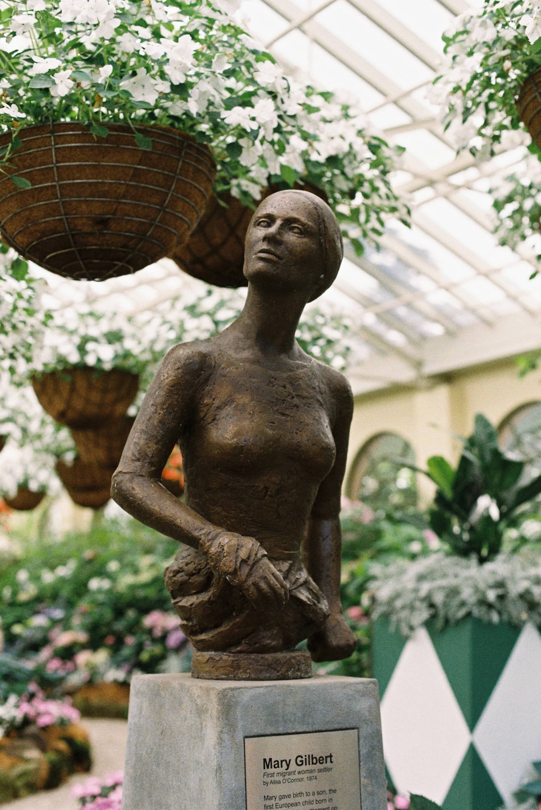 Bust de bronz înconjurat de flori